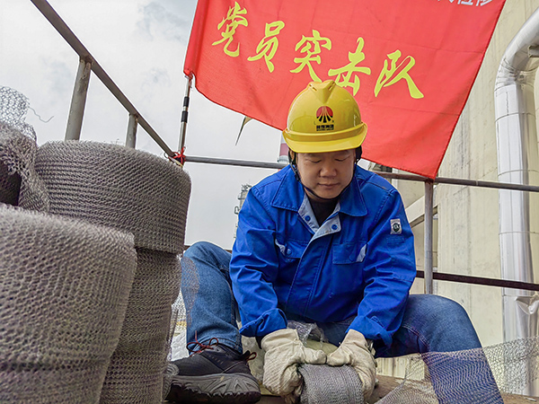 5月10日中午，在動力車間三期工藝除氧器平臺上，黨員突擊隊隊長李鑫正在纏繞新填料.jpg